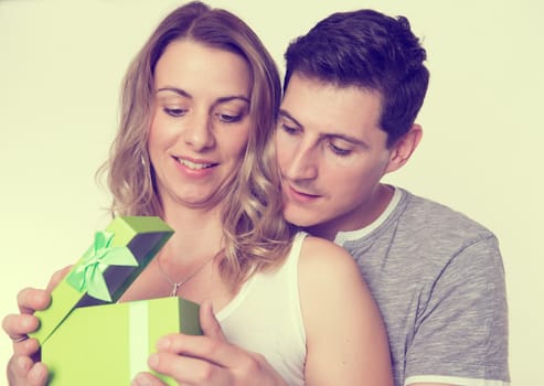 young beautiful couple with gift box in front of white background