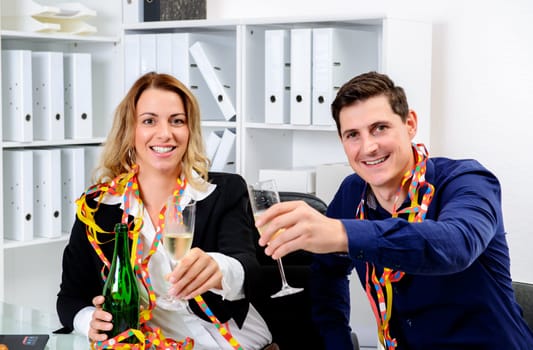 young businessman and businesswoman celebrating together in the office