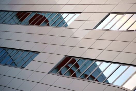 The modern rows of windows and façade cladding of an office and commercial building.