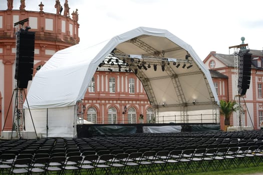 Wiesbaden,Germany - July 14,2016: A concert stage set up with rows of seats for a classical concert on the castle grounds with Schloss Biebrich in the background on July 14,2016 in Wiesbaden.