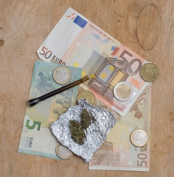 marijuana in tin foil with pipe and euro money background