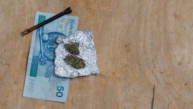 portion of marijuana in tin foil with pipe and polish pln money