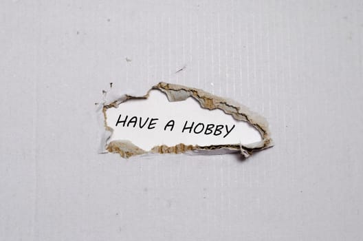 The word have a hobby appearing behind torn paper