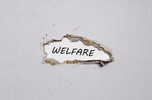 The word welfare appearing behind torn paper