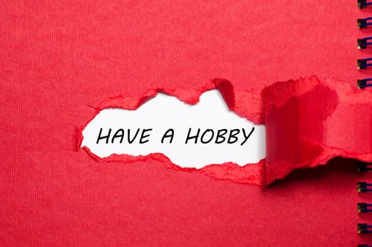 The word have a hobby appearing behind torn paper