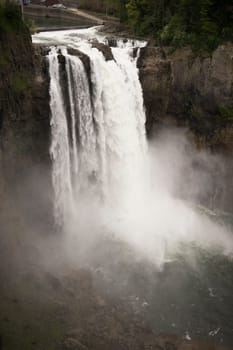 A large flow of water travels over the ridge creating a waterfall