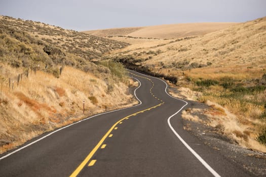 Two Lane blacktop road leads through scenic Oregon State