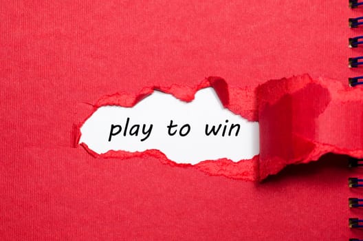 The word play to win appearing behind torn paper