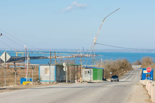 Taman, Russia - November 5, 2016: Construction of a bridge across the Kerch Strait, the control checkpoint on the road leading to the building, at the shoreline of the Taman peninsula, as of November 2016