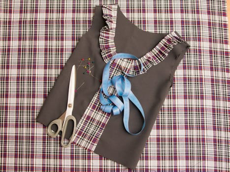 Top view of the workpiece and the children's school dress sewing supplies
