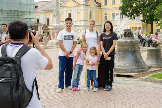 Sergiev Posad - August 10, 2015: Foreign tourists are photographed with Russian visitors on the background of the bells in the Holy Trinity St. Sergius Lavra