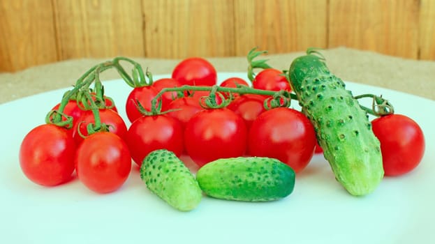 fresh cucumbers and red tomatoes on the plate white