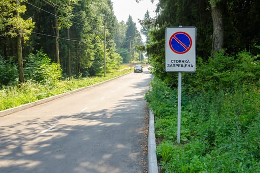 Traffic sign "No parking"" on the forest road on which the moving car"