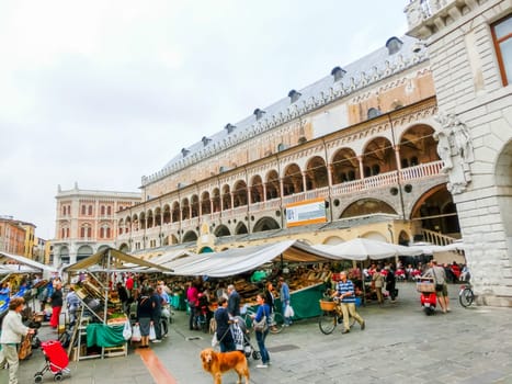 Padua, Italy - September 19, 2014: Scene of Palazzo della Ragione with local market and tourists, in Padua, Veneto, Italy