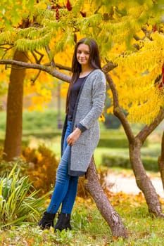 Portrait of pretty teen girl in autumn park. Smiling happy girl portrait, autumn outdoor.