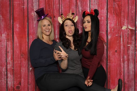 Cheeky girls goofy in front of a photo booth