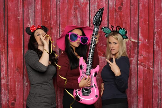 3 girls have fun with a photo booth