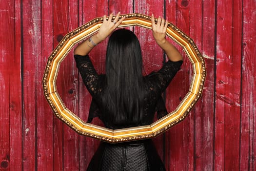 Mysterious woman stands with her back in a frame