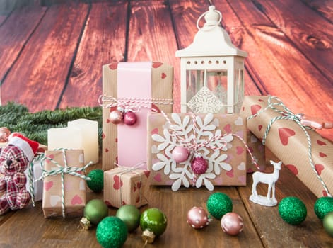 Small gifts and colorful Christmas decorations on rustic wood