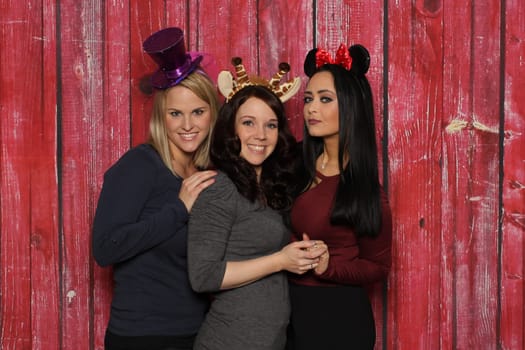 3 cute girls smiling in front of a photo booth