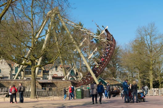 KAATSHEUVEL, NETHERLANDS - MARCH 13, 2016: Unknown people at a swinging ship in The Efteling, the largest theme park in the Benelux