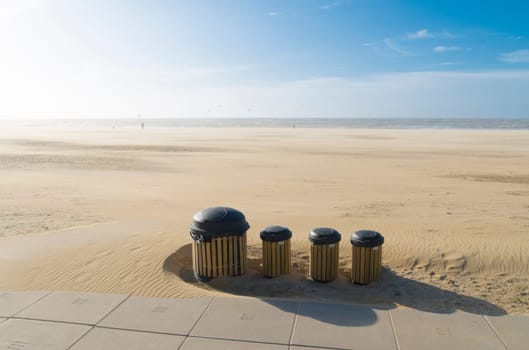 row dust bins on a desolate windy north sea beach in the netherlands