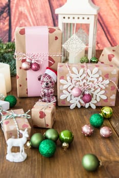Small gifts and colorful Christmas decorations on rustic wood