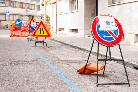 No parking sign post for road works..In the background, other road signs blurred