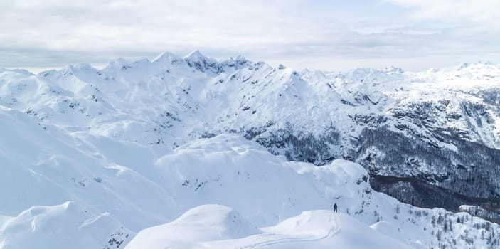 Freeride snowboarder on the top of the mountain. Extreme winter freeride. Amazing landscape of snowy Alp mountains, Vogel, Slovenia.
