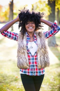 ethnic woman wearing fashion fall outfit outdoors int he park