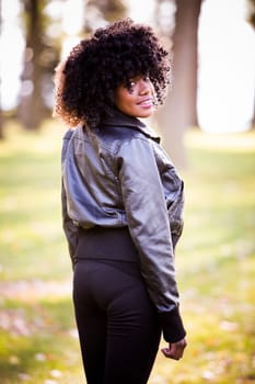 ethnic woman wearing fashion fall outfit outdoors int he park