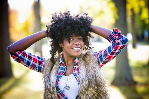 ethnic woman wearing fashion fall outfit outdoors int he park