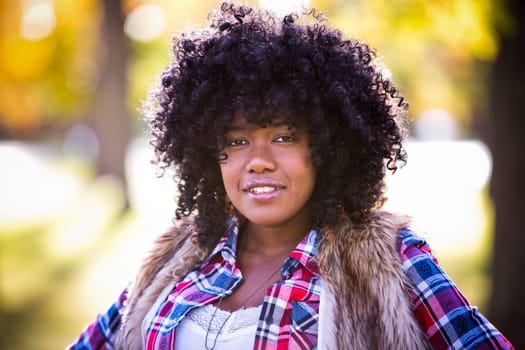 ethnic woman wearing fashion fall outfit outdoors int he park