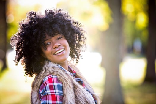 ethnic woman wearing fashion fall outfit outdoors int he park
