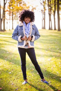 ethnic woman wearing fashion fall outfit outdoors int he park