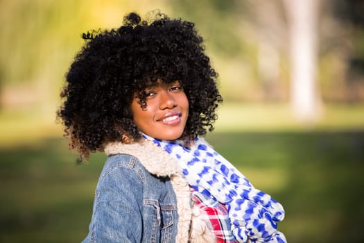 ethnic woman wearing fashion fall outfit outdoors int he park