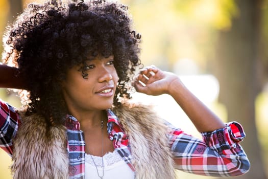ethnic woman wearing fashion fall outfit outdoors int he park