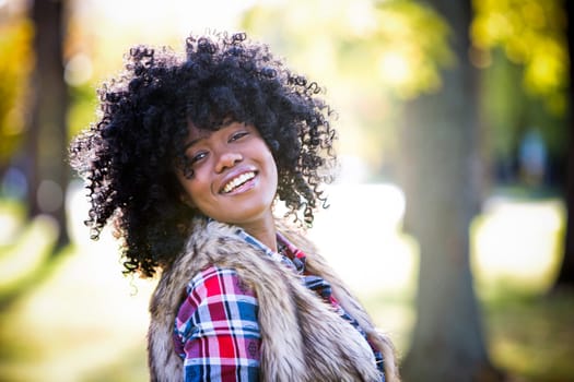 ethnic woman wearing fashion fall outfit outdoors int he park