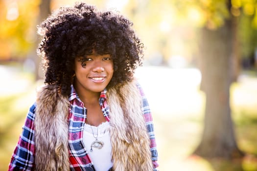 ethnic woman wearing fashion fall outfit outdoors int he park