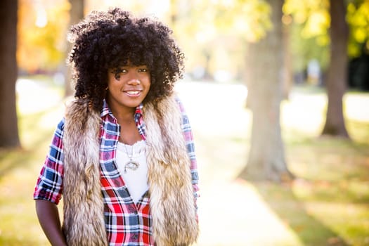 ethnic woman wearing fashion fall outfit outdoors int he park