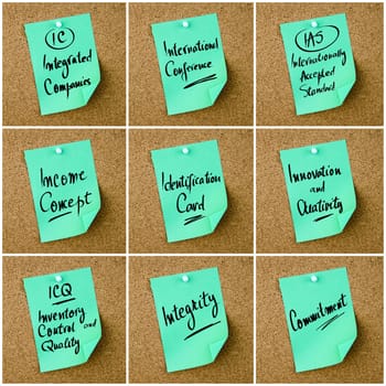 Collage of Business Acronyms written on green paper note pinned on cork board with white thumbtack, copy space available