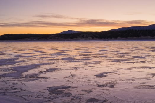 Warm tones of sunrise on Abraham Lake in Winter.