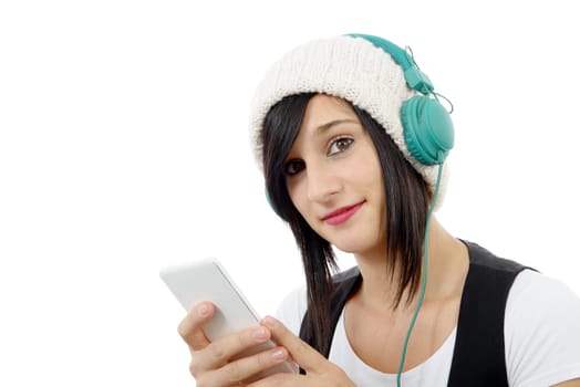 young brunette listening to music with headphones and  phone on white