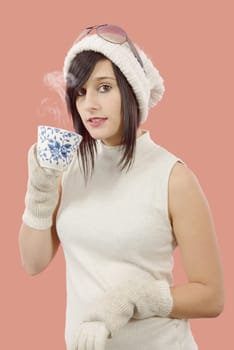 pretty young brunette woman with a cup of tea on pink background