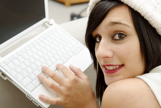 young brunette girl student lying on the couch with a laptop