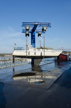 one big crane lift up the sailingboat from the water