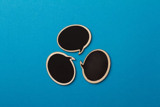Top view of round chalk board speech bubbles on blue background, metaphor concept for communication