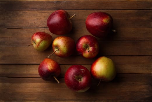 Horizontal top view of organic small raw apples on vintage wood board