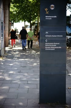 Bremen,Germany - August 30,2016: Walkers at a sign and a trail marker in front of the old town on August 30,2016 in Bremen.