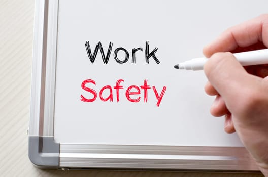 Human hand writing work safety on whiteboard